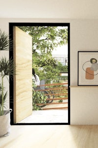 a room with an open door and a plant on the floor